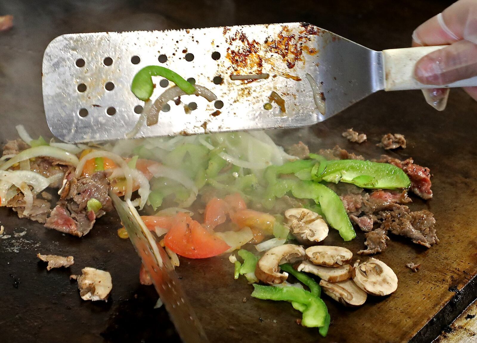 A Steak Bomb sub sizzles on the grill at Jon Smith Subs. BILL LACKEY/STAFF