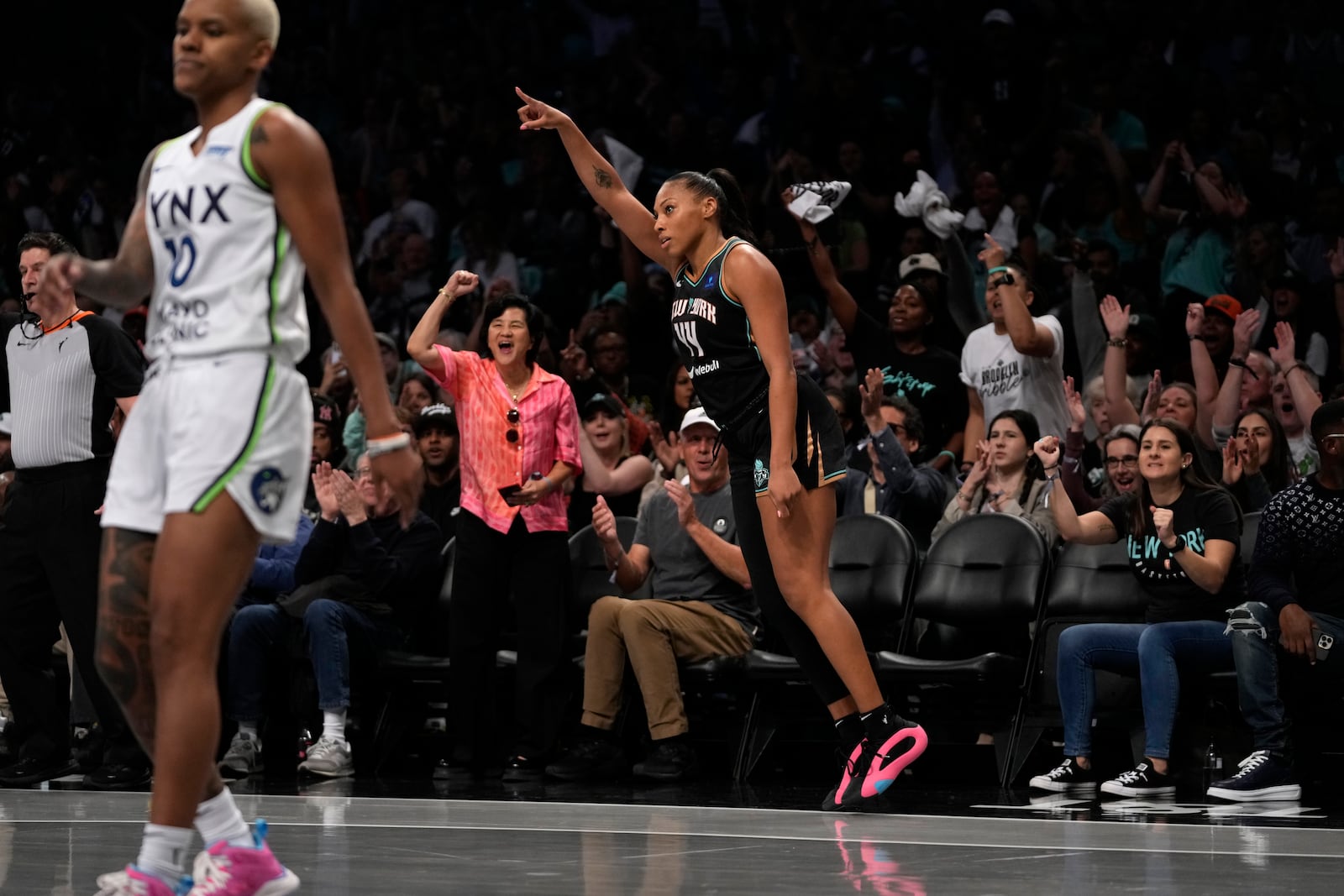 New York Liberty's Betnijah Laney-Hamilton, front right, reacts after shooting a 3-point basket during the first half in Game 2 of a WNBA basketball final playoff series against the Minnesota Lynx, Sunday, Oct. 13, 2024, in New York. (AP Photo/Pamela Smith)