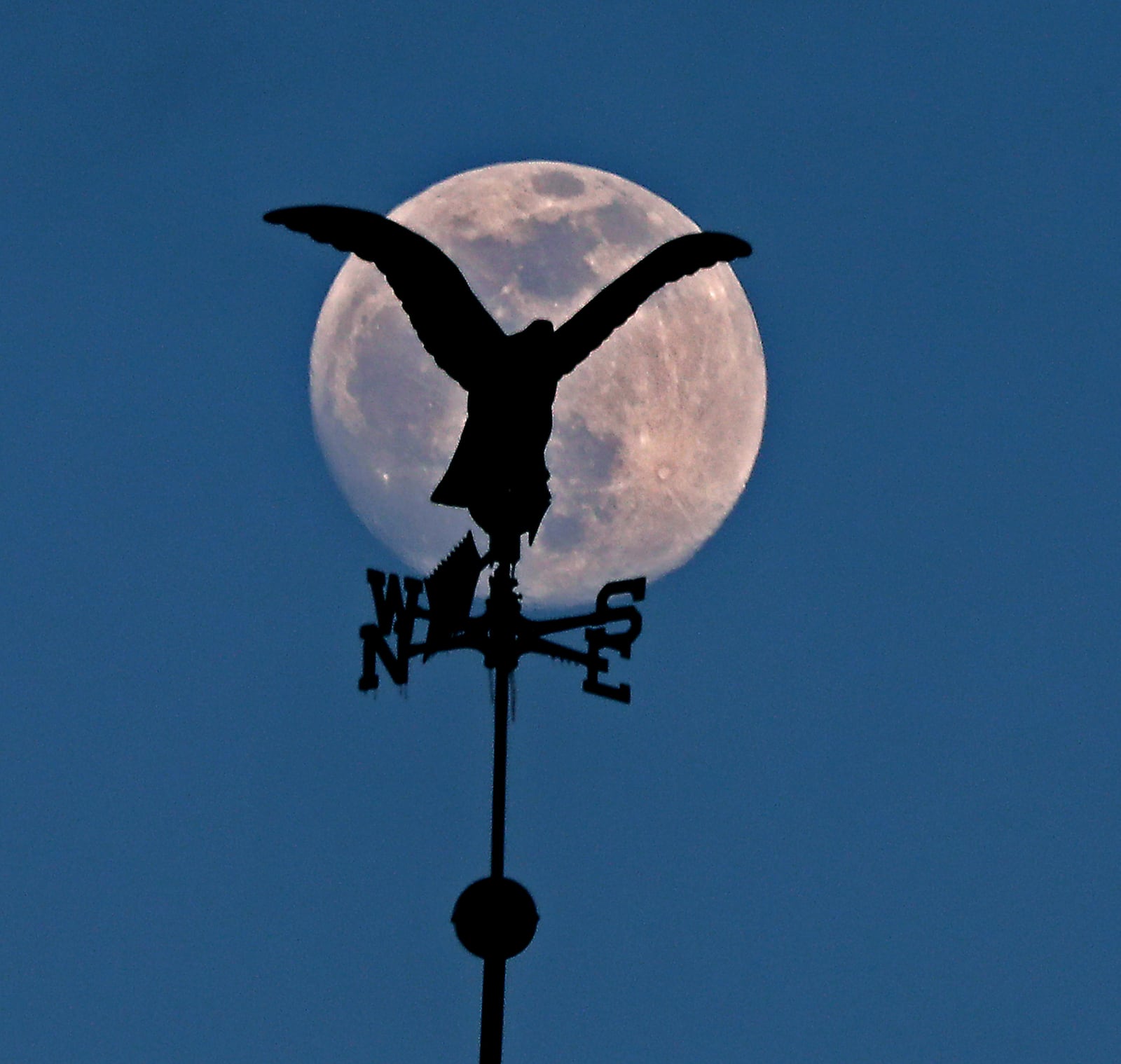 A weathervane on top of Huntington Bank in downtown Springfield stands out against the full moon Friday evening. BILL LACKEY/STAFF