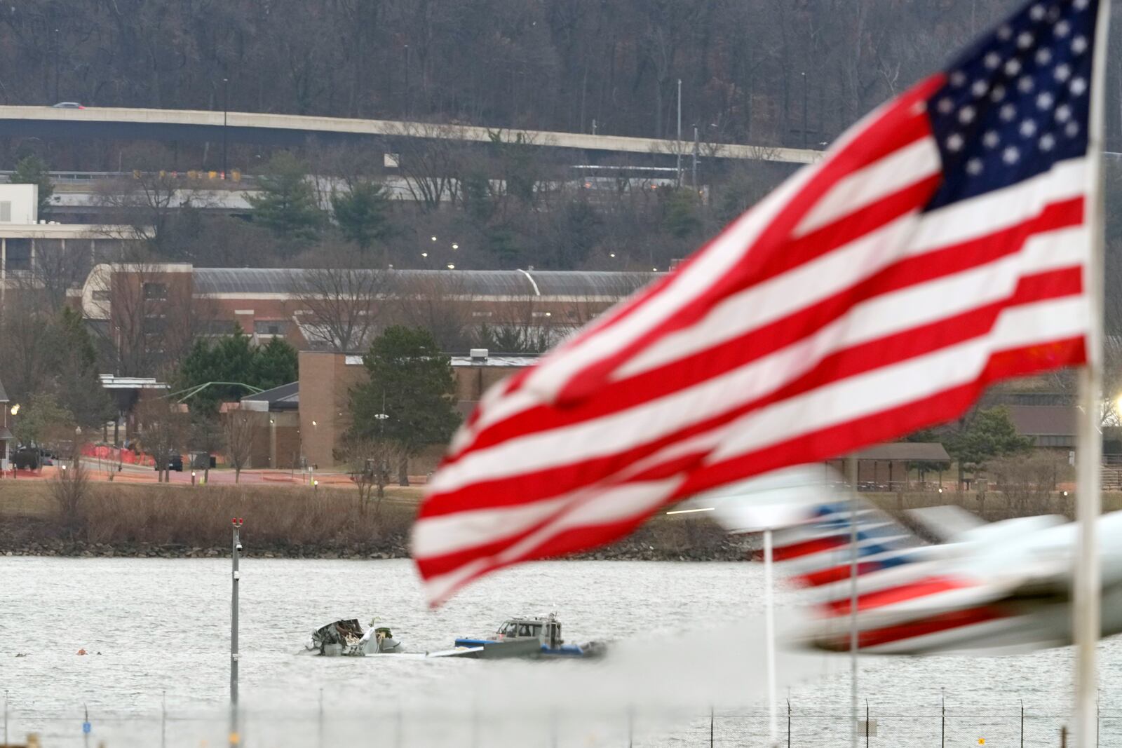 Search efforts are seen around a wreckage site of a deadly midair collision between an American Airlines jet and an Army helicopter, in the Potomac River near Ronald Reagan Washington National Airport, Friday, Jan. 31, 2025, in Arlington, Va., as an American Airlines jet lifts off from the airport. (AP Photo/Alex Brandon)