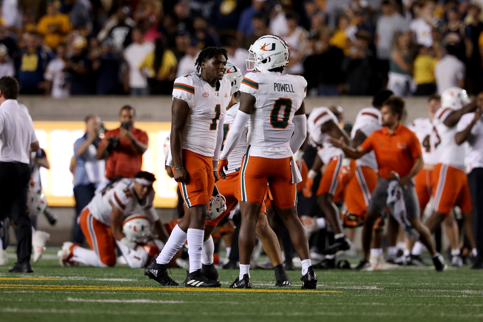 Miami quarterback Cam Ward (1) and and defensive back Mishael Powell (0) celebrate against California during the second half of an NCAA college football game in Berkeley, Calif., Saturday, Oct. 5, 2024. (AP Photo/Jed Jacobsohn)