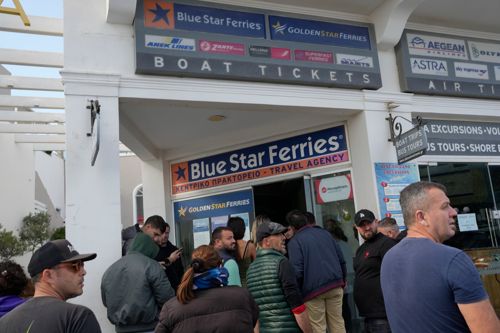 People wait to buy boat and air tickets as Greek authorities are taking emergency measures in response to intense seismic activity on the popular Aegean Sea holiday island of Santorini, southern Greece, Monday, Feb. 3, 2025. (AP Photo/Petros Giannakouris)