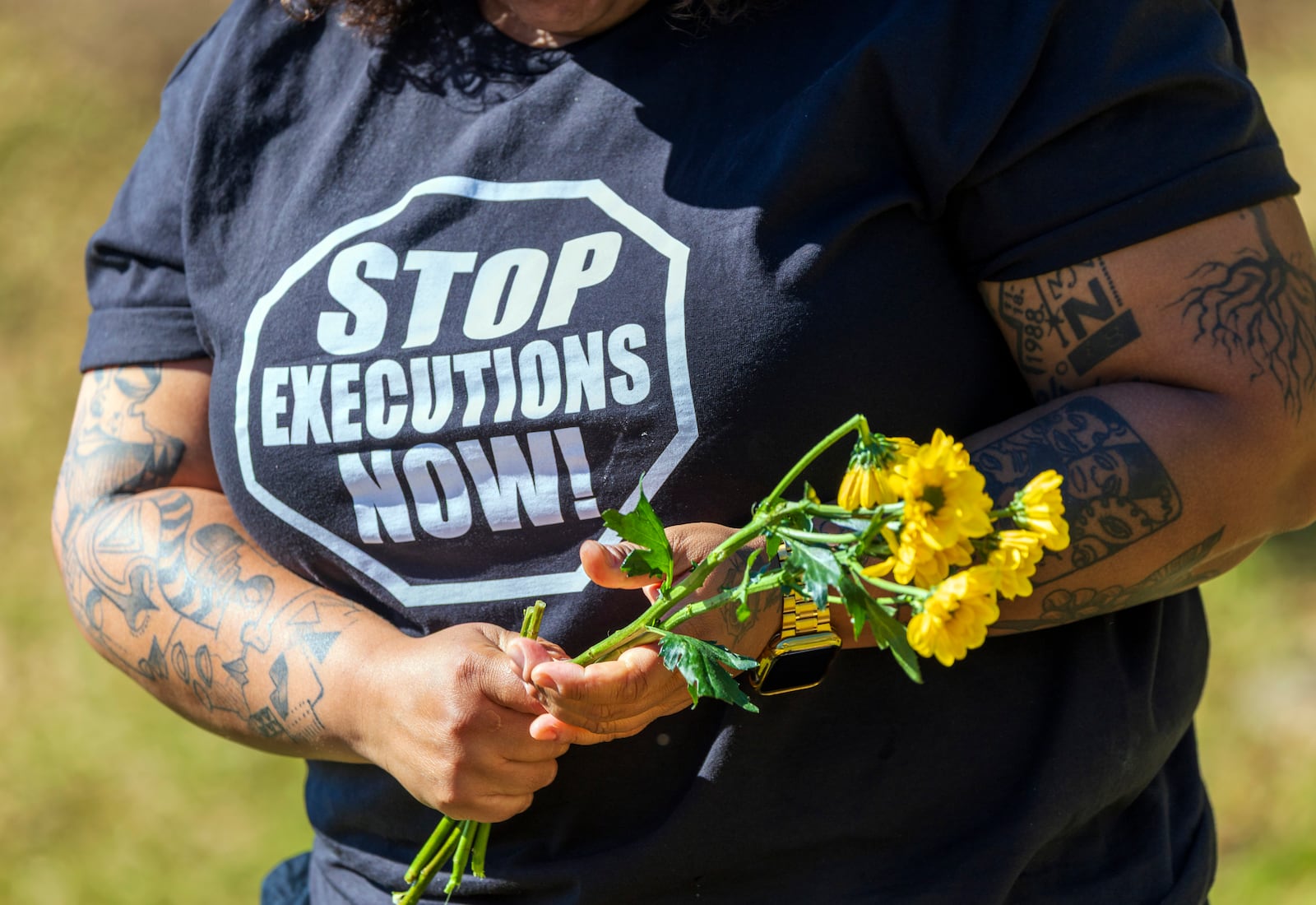 Lauren Sapp, deputy director of The Promise of Justice Initiative, helps place flowers outside Louisiana State Penitentiary in Angola, La., as supporters and faith leaders gather for Hoffman's planned execution Tuesday, March 18, 2025. Hoffman was convicted in the 1996 murder of Mary "Molly" Elliott. (Chris Granger/The Times-Picayune/The New Orleans Advocate via AP)