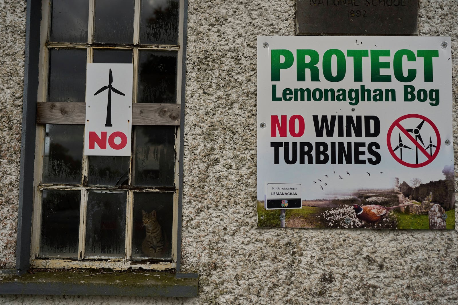 Protest banners against wind turbines displayed on a building in Lemanaghan, Ireland, Wednesday, Oct. 16, 2024. (AP Photo/Bram Janssen)