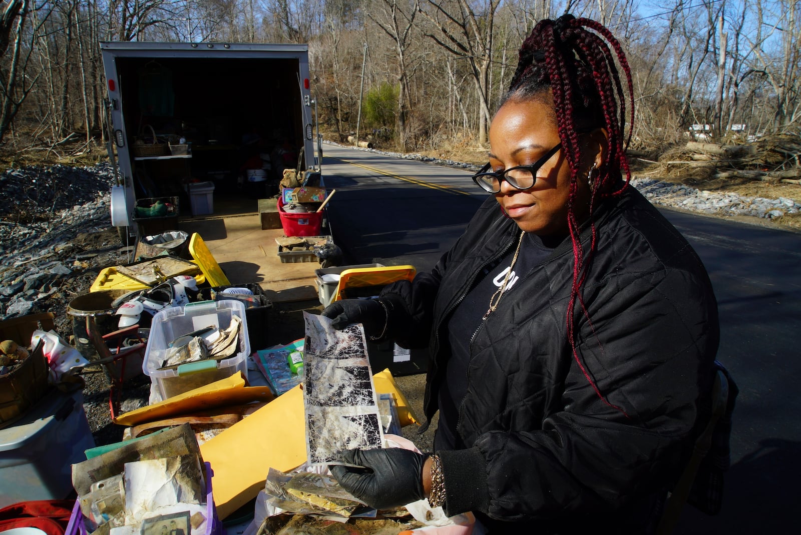 Angie McGee holds up her lost sonogram pictures while looking through Jill Holtz's collection of objects found in debris from Hurricane Helene on Friday, Feb. 7, 2025, in Swannanoa, N.C. (AP Photo/Allen G. Breed)