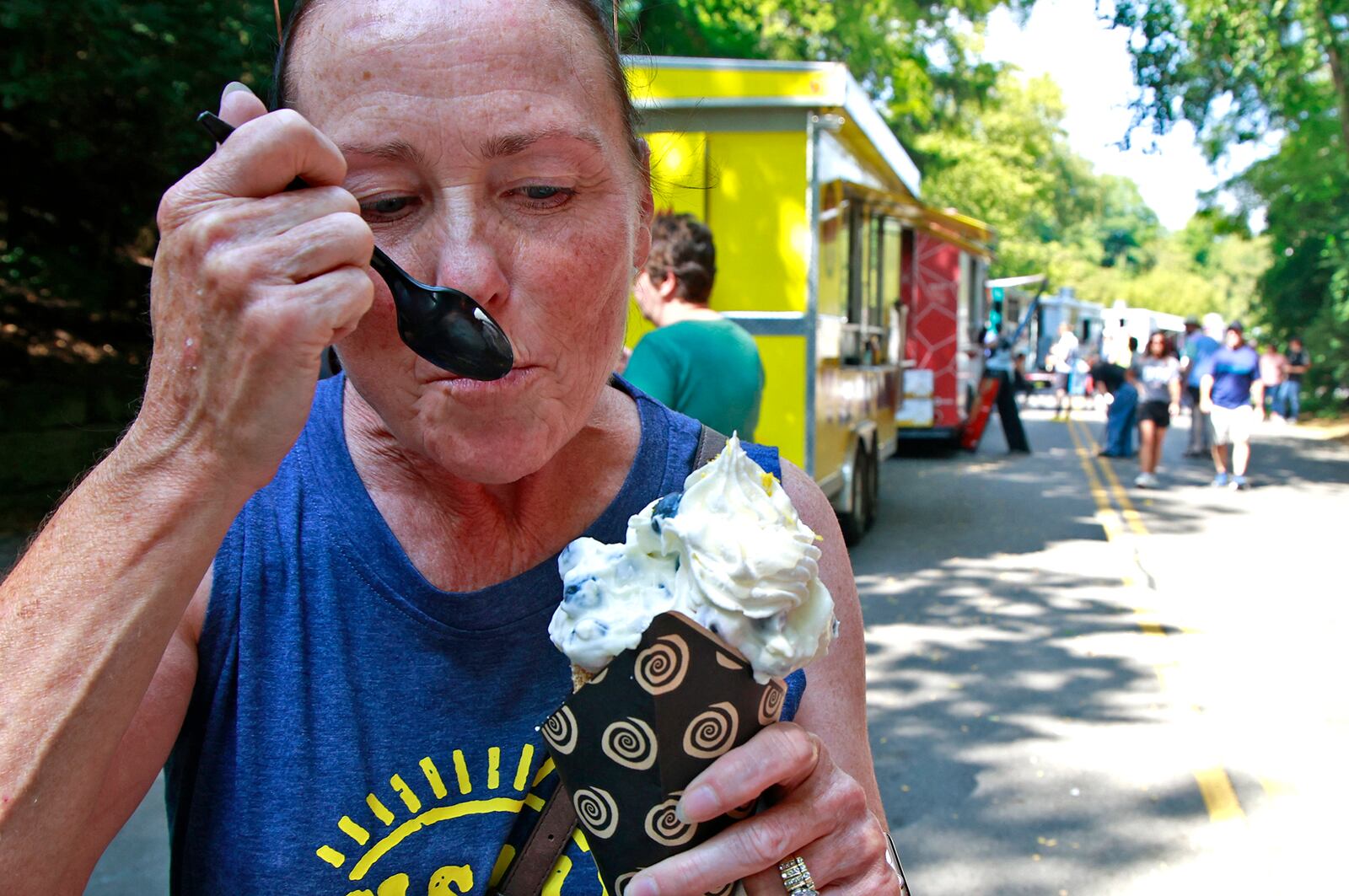 Peggy Collins enjoys a chimney cake from the Childers' Chimney Cakes food truck Saturday, August 17, 2024 at the 10th annual Springfield Rotary Gourmet Food Truck Competition in Veterans Park. BILL LACKEY/STAFF