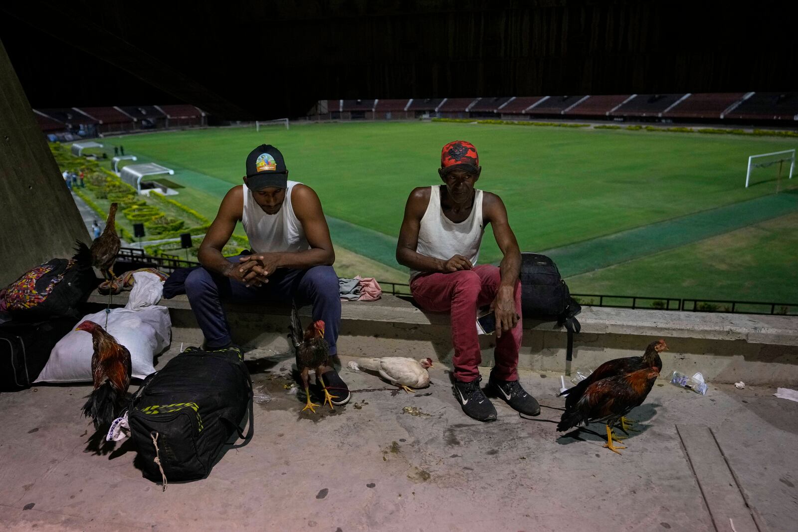 People displaced by violence in towns across the Catatumbo region, where rebels of the National Liberation Army, or ELN, have been clashing with former members of the Revolutionary Armed Forces of Colombia, take shelter at a soccer stadium in Cucuta, Colombia, Sunday, Jan. 19, 2025. (AP Photo/Fernando Vergara)