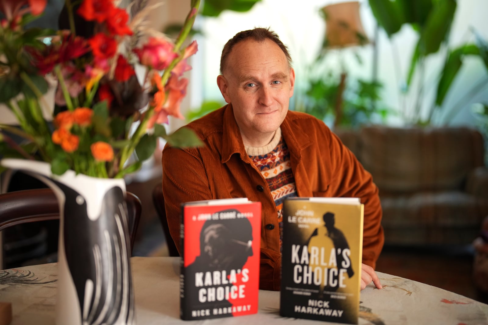 British author Nick Harkaway, son of John le Carre, poses for a photograph with copies of his book, during an interview with The Associated Press, at his home, in London, Thursday, Oct. 24, 2024. (AP Photo/Kin Cheung)