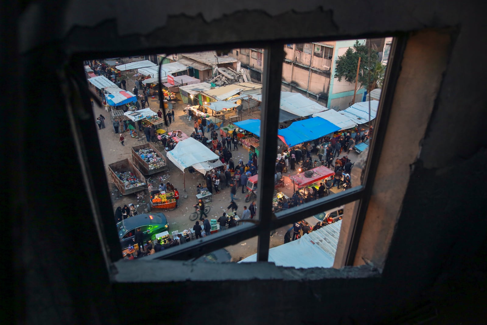 A market is seen through a window in Khan Younis, central Gaza Strip, Saturday Jan. 18, 2025.(AP Photo/(AP Photo/Jehad Alshrafi)