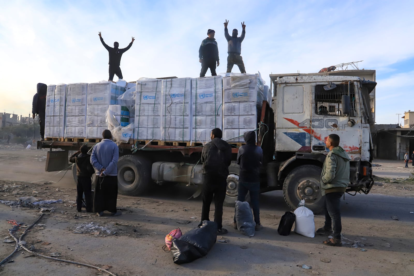 Humanitarian aid trucks enter through the Kerem Shalom crossing from Egypt into the Gaza Strip, as a ceasefire deal between Israel and Hamas went into effect, Sunday, Jan. 19, 2025. (AP Photo/Mariam Dagga)