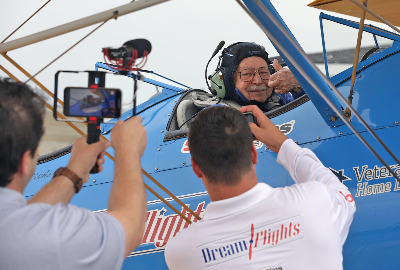 World War II veteran Albert Carr, 96, gives a thumbs up before taking off in a restored Stearman biplane for a Dream Flight Wednesday at Grimes Field in Urbana. BILL LACKEY/STAFF