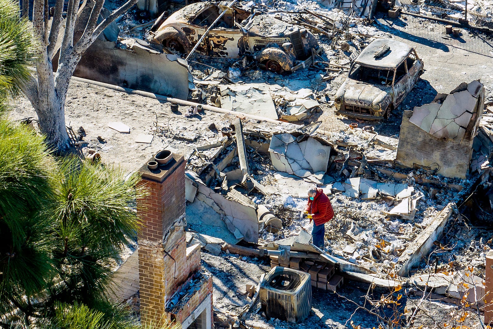 A woman search inside a destroyed home by the Eaton Fire in Altadena, Calif., on Tuesday, Jan. 21, 2025. (AP Photo/Noah Berger)