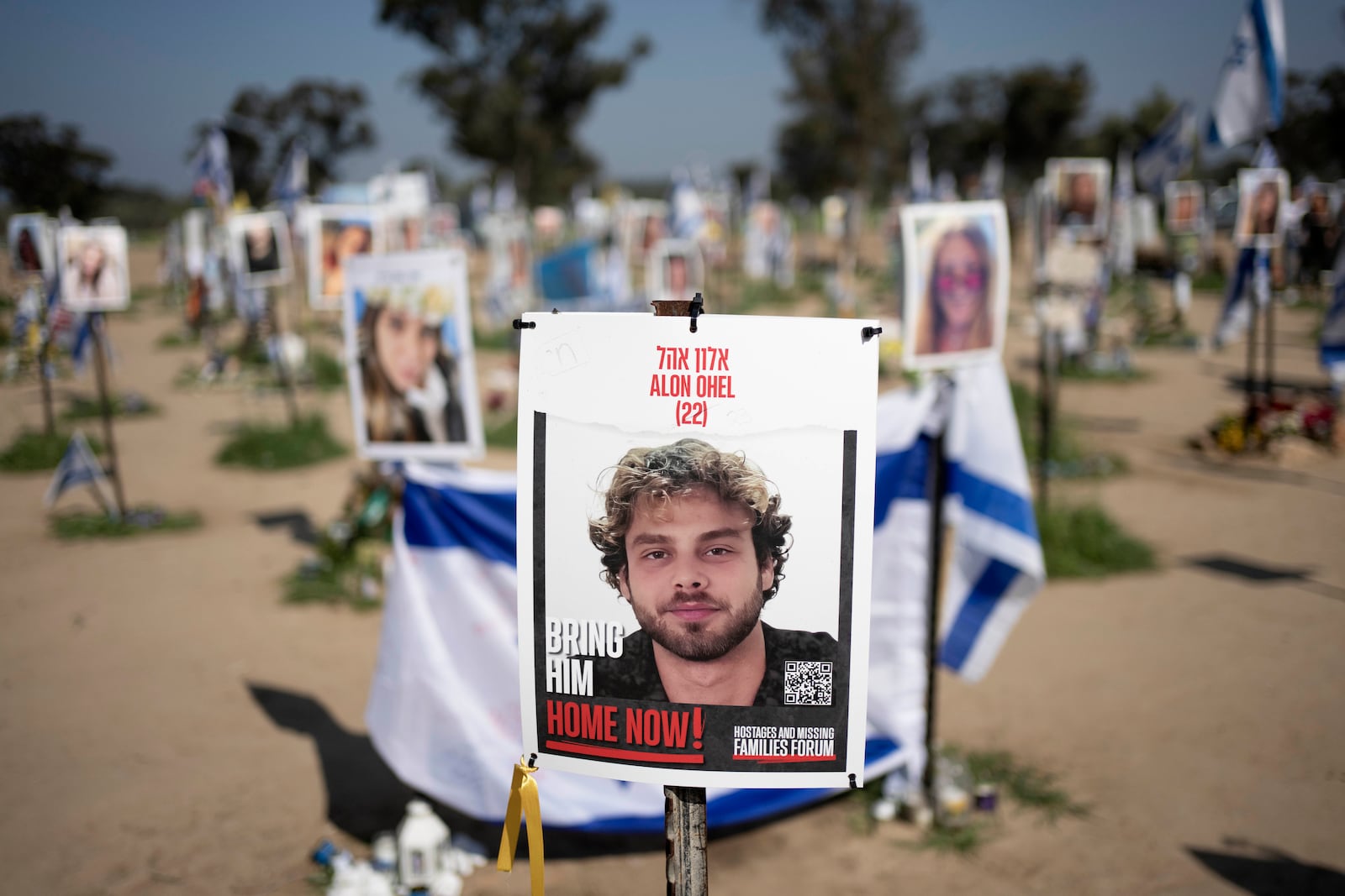 FILE - A poster depicting Israeli hostage Alon Ohel is displayed in Re'im, southern Israel at the Gaza border, Feb. 26, 2024, at a memorial site for the Nova music festival site where he was kidnapped to Gaza by Hamas on Oct. 7, 2023. (AP Photo/Maya Alleruzzo, File)