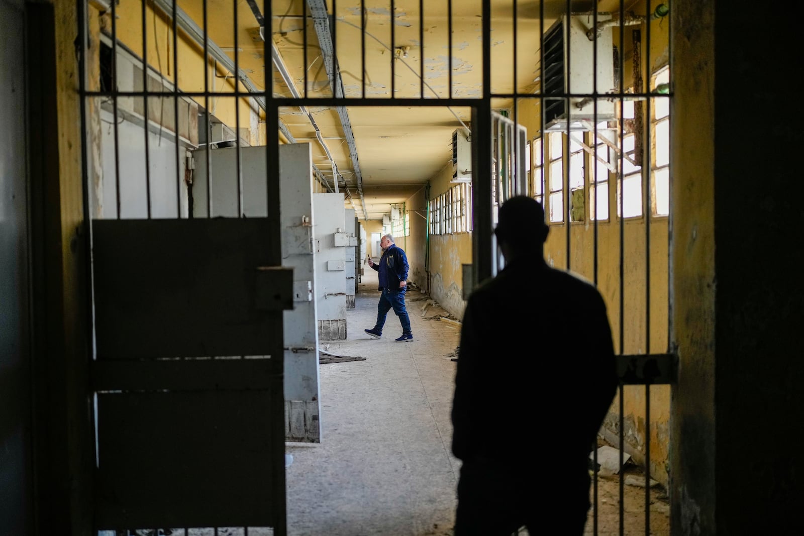 Two men walk along the cells gallery of the infamous Saydnaya military prison on the outskirts of Damascus, Syria, Sunday Jan. 12, 2025. (AP Photo/Mosa'ab Elshamy)