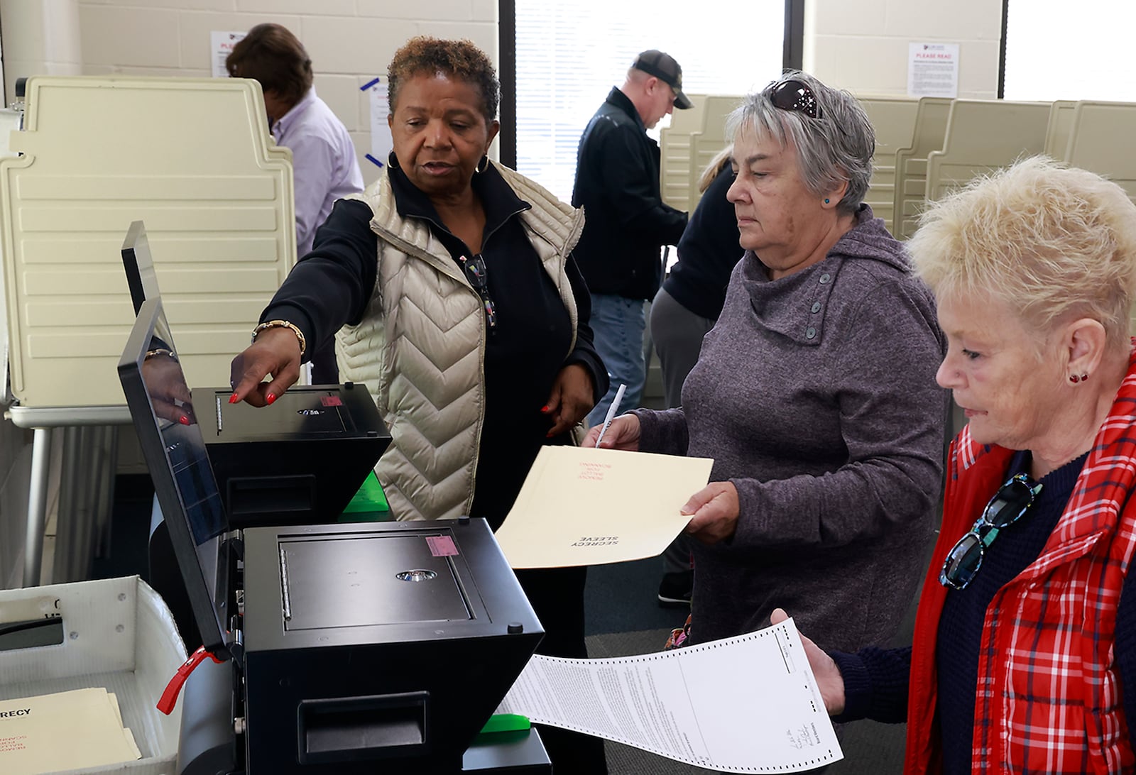 Cassandra Castleberry helps early voters place their ballots in the voting machines at the Clark County Board of Elections Thursday, Oct. 18, 2024. BILL LACKEY/STAFF