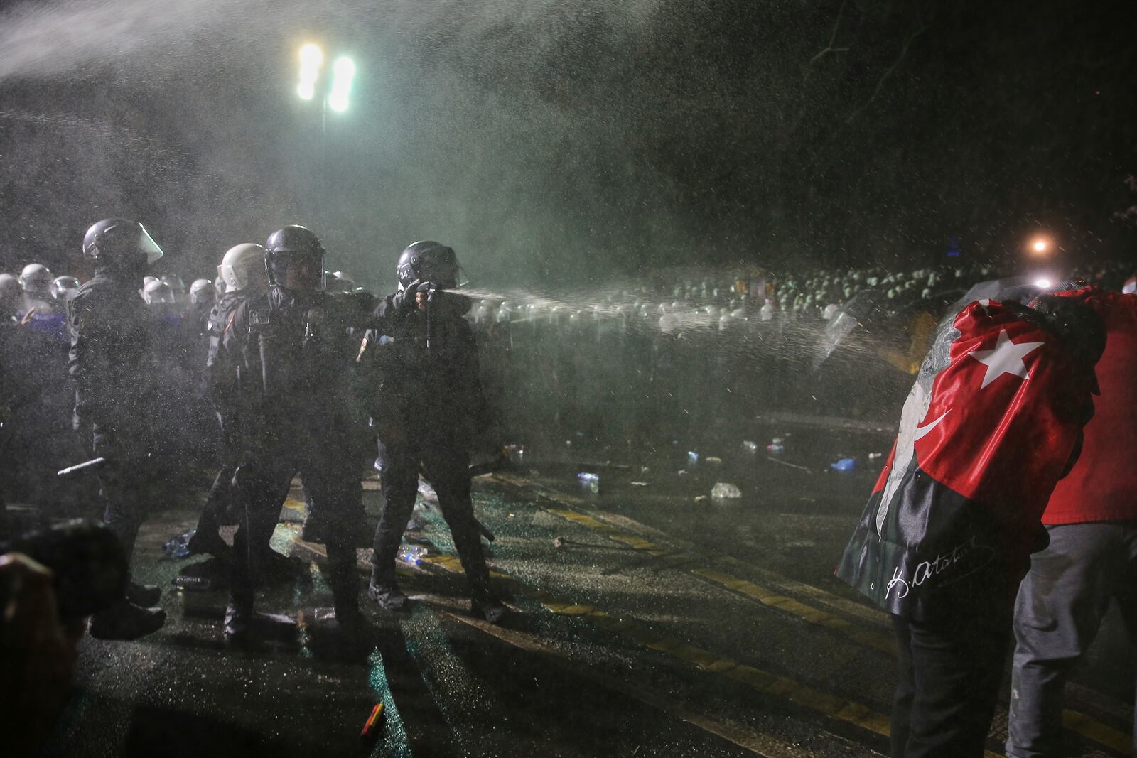 Riot police officers use pepper spray to clear protesters during a protest after Istanbul's Mayor Ekrem Imamoglu was arrested and sent to prison, in Istanbul, Turkey, Sunday, March 23, 2025. (AP Photo/Huseyin Aldemir)