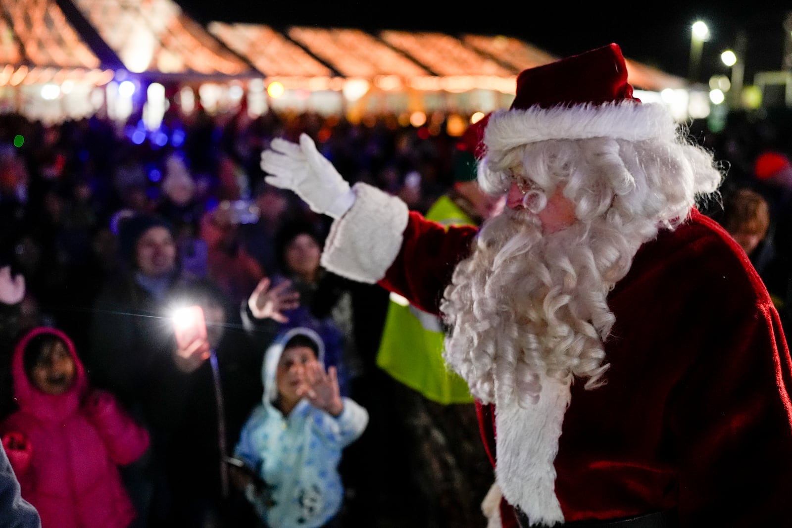 Santa Claus waves to children during a visit of the CSX Holiday Express, Thursday, Nov. 21, 2024, in Erwin, Tenn. The railway company held a celebration and concert for the town affected by Hurricane Helene. (AP Photo/George Walker IV)