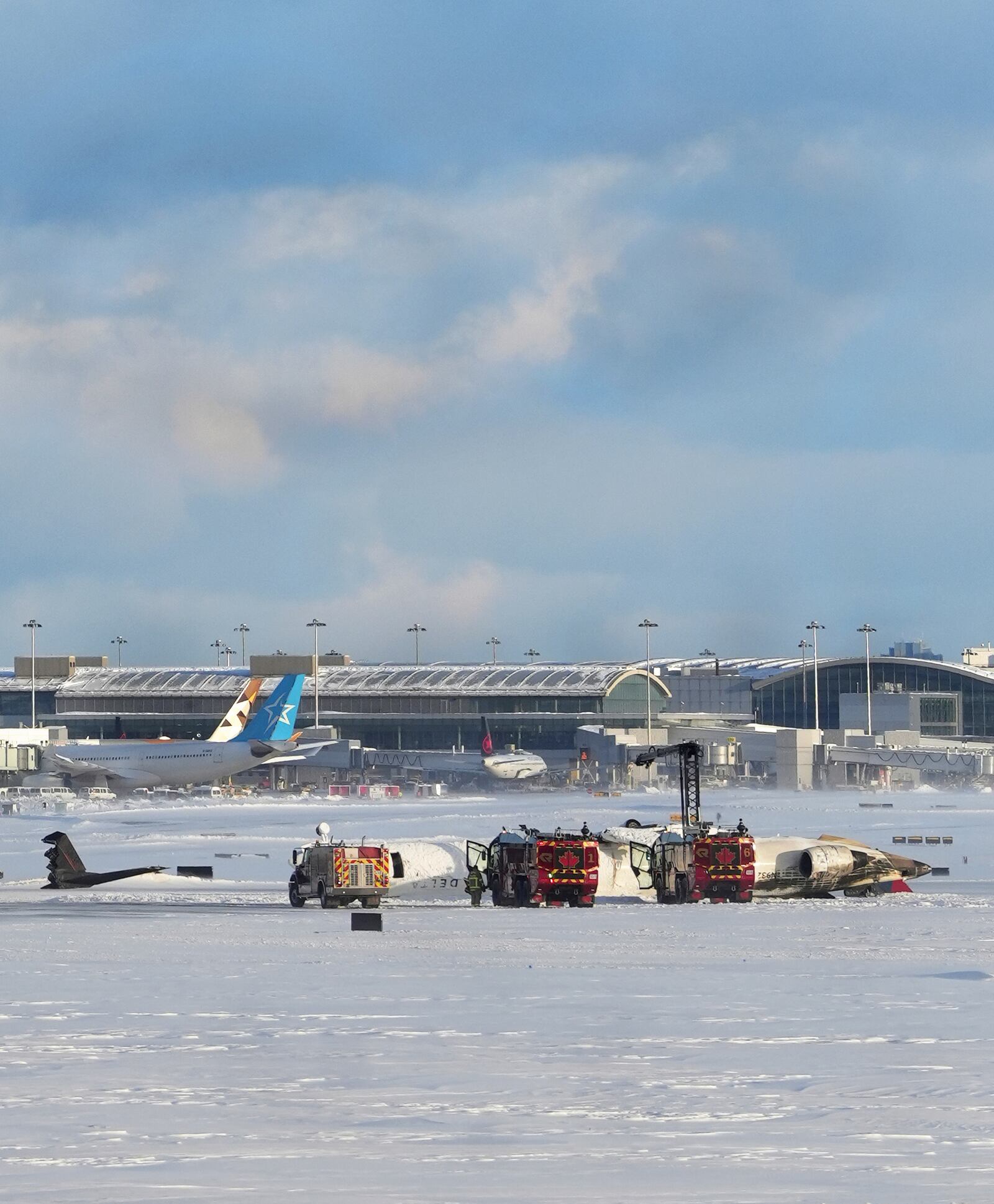 An aircraft from Delta Airlines sits upside down on the tarmac at Toronto Pearson International airport, Monday, Feb. 17, 2025. (Teresa Barbieri/The Canadian Press via AP)