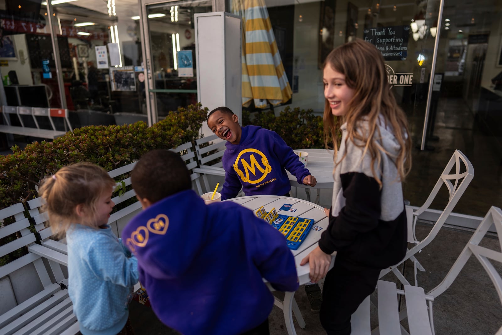 Eaton Fire evacuees Ceiba Phillips, right, and his sister, Quoia, left, share a light moment with Justin Graham, center, and his brother, Russell, outside an ice cream shop in Pasadena, Calif., Wednesday, Feb. 5, 2025. (AP Photo/Jae C. Hong)