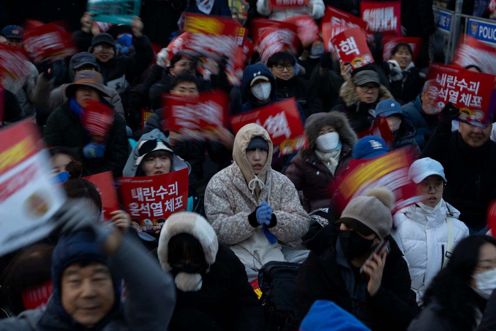 People wait in freezing weather outside the National Assembly during the voting for the impeachment of South Korean President Yoon Suk Yeol, following the President's short-lived martial law declaration in Seoul, South Korea, Saturday, Dec. 7, 2024. (AP Photo/Ng Han Guan)