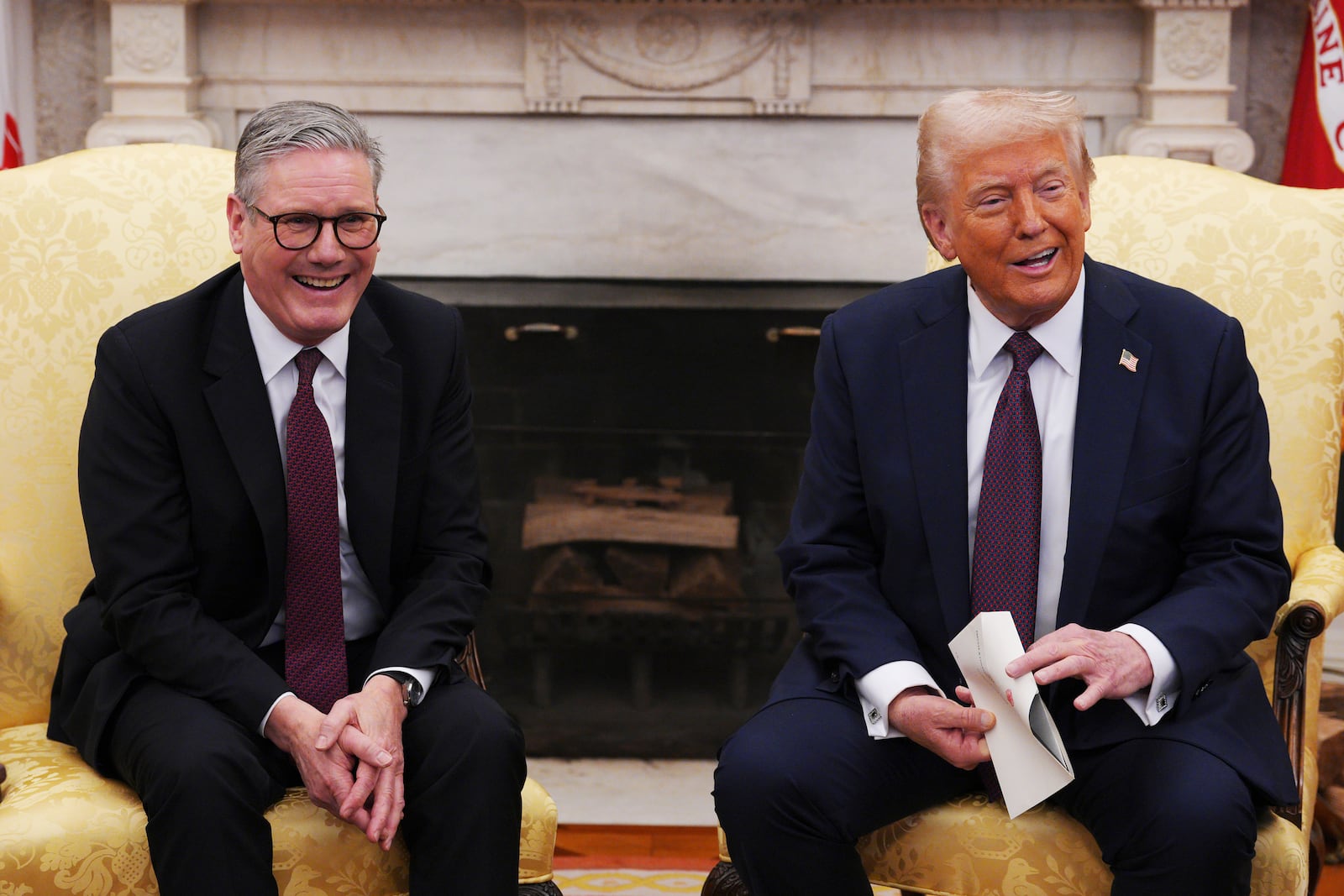 British Prime Minister Keir Starmer, left, hands an invitation from King Charles III to President Donald Trump at the White House, Thursday, Feb. 27, 2025, in Washington. (Carl Court/Pool via AP)