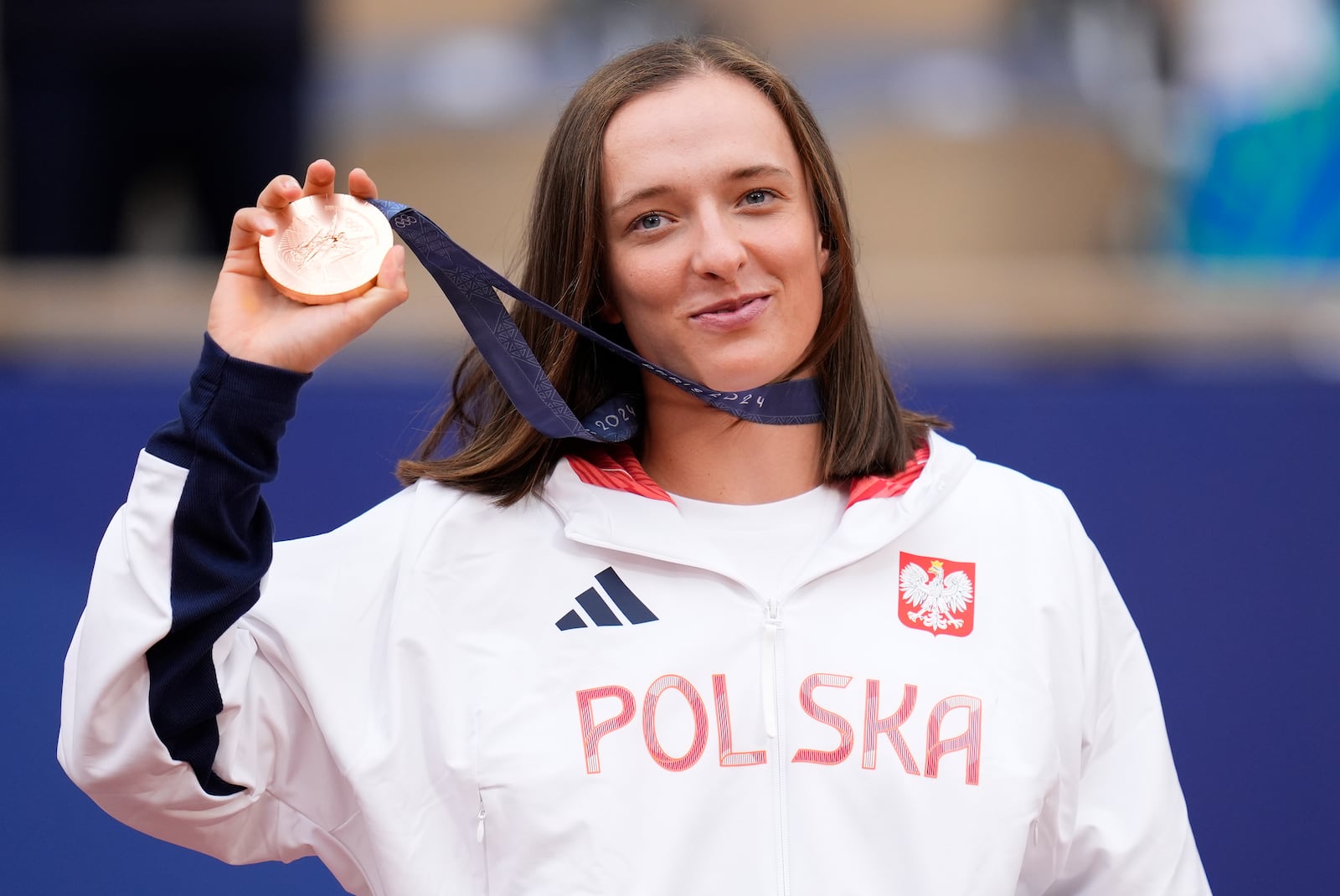 FILE - Poland's Iga Swiatek shows her bronze medal after the Women's Singles tennis final at the Roland Garros stadium at the 2024 Summer Olympics, Saturday, Aug. 3, 2024, in Paris, France. (AP Photo/Manu Fernandez, File)