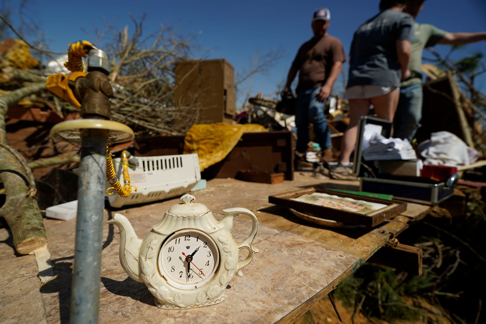 The antique teapot clock of Donna Blansett, is one of the few items that family and friends recovered intact from their mobile home that was destroyed when a series of storms passed Tylertown, Miss., Sunday, March 16, 2025. (AP Photo/Rogelio V. Solis)