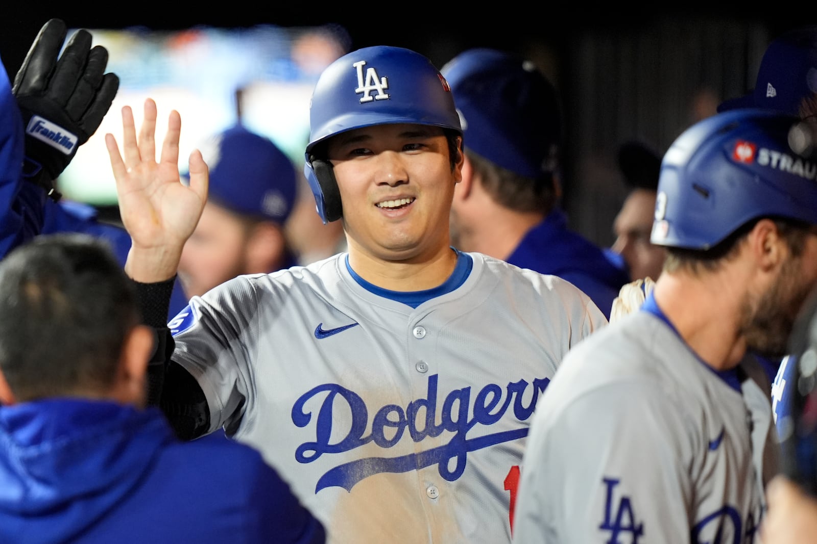 Los Angeles Dodgers' Shohei Ohtani celebrates in the dugout after scoring on a double by Mookie Betts during the fourth inning in Game 4 of a baseball NL Championship Series against the New York Mets, Thursday, Oct. 17, 2024, in New York. (AP Photo/Frank Franklin II)