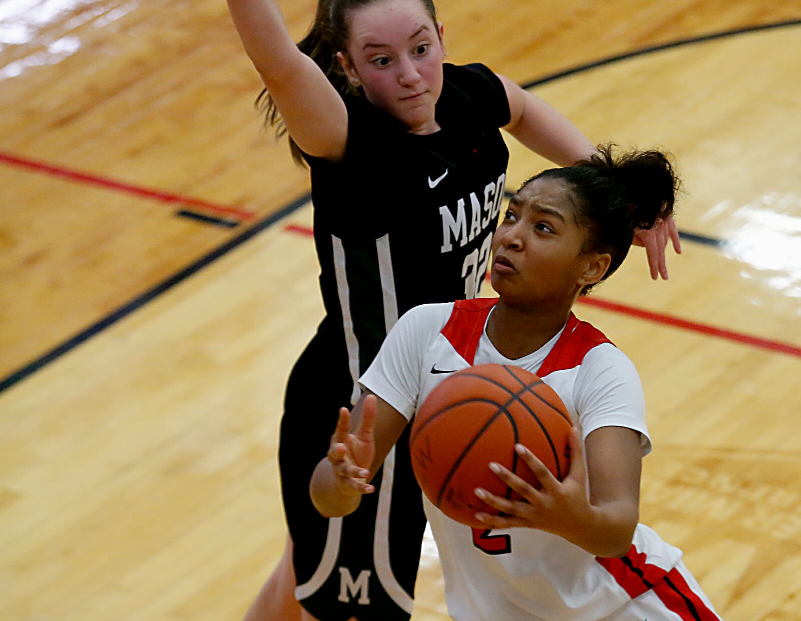 Lakota West High School guard Chance Gray goes up to score against Mason guard Margo Mattes during a Greater Miami Conference basketball game in West Chester Jan. 23, 2021. Contributed photo by E.L. Hubbard