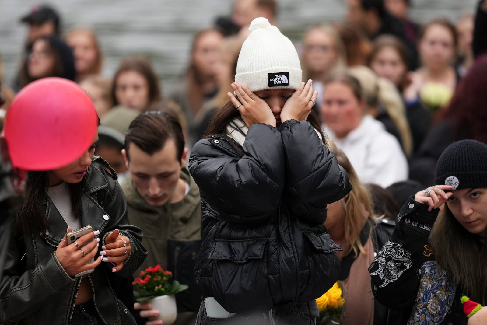 Fans react as they gather near the Peter Pan statue in Hyde Park, London to pay tribute to late British singer Liam Payne, former member of the British pop band One Direction, Sunday, Oct. 20, 2024. (Photo by Scott A Garfitt/Invision/AP)