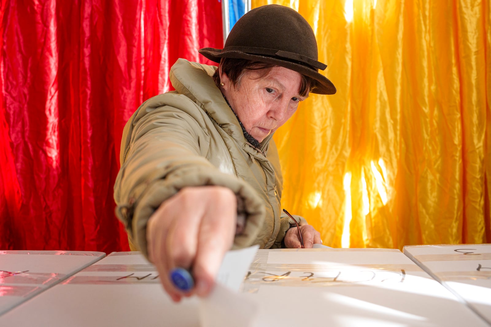 A woman casts her vote in the country's presidential elections, in Bucharest, Romania, Sunday, Nov. 24, 2024. (AP Photo/Andreea Alexandru)