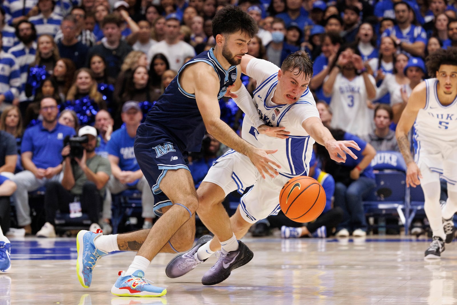 Duke's Cooper Flagg (2) attempts to steal the ball from Maine's Christopher Mantis, left, during the second half of an NCAA college basketball game in Durham, N.C., Monday, Nov. 4, 2024. (AP Photo/Ben McKeown)