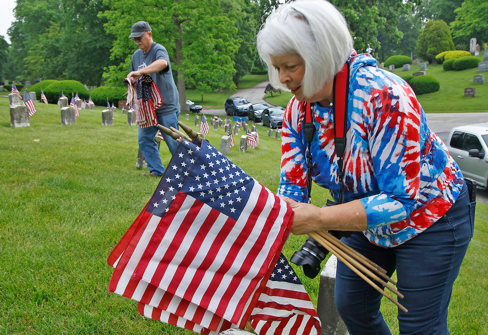 Terri Norris joined the volunteers Saturday morning, May 18, 2024 as they placed over 3,000 American flags on the graves of service men and women interred in Ferncliff Cemetery for Memorial Day. Over 40 volunteers, including a large group from Werner Enterprises, placed flags on the central GAR (Civil War) mound, WWI section, WWII section and the Annex with more recent graves. The event was organized by Ferncliff Cemetery and Arboretum. BILL LACKEY/STAFF