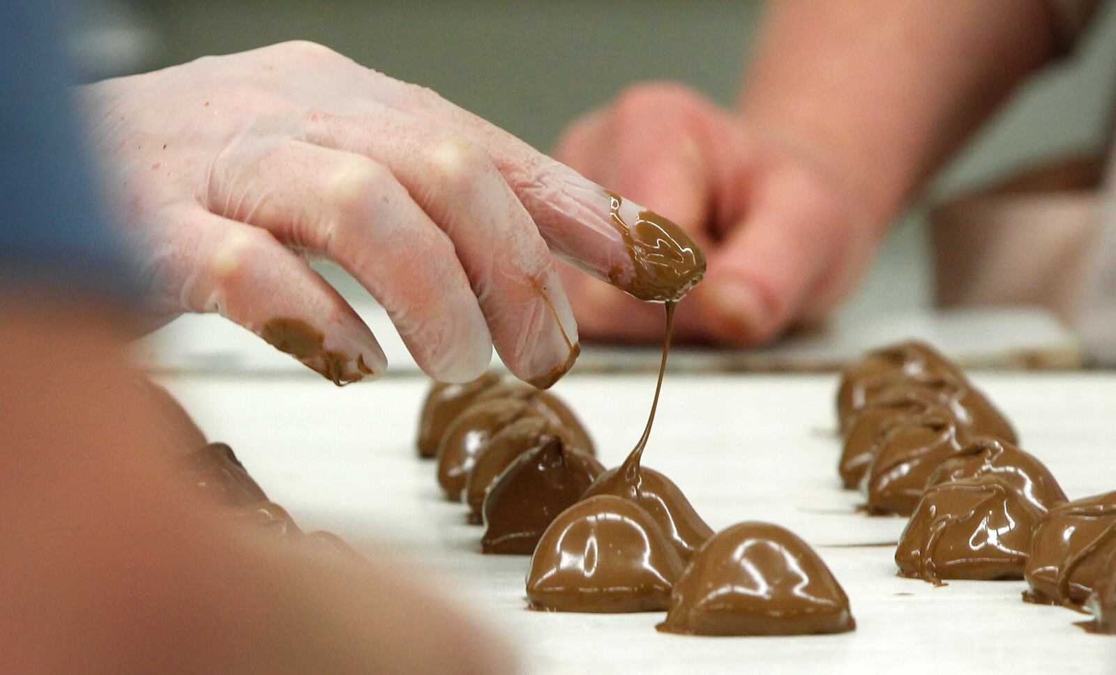 Esther Price Fine Chocolates still has candies that are hand-strung. A finger tip dipped into fresh chocolate creates a heart on top of the peanut butter creams and a swirl on top of the hand-rolled cherries. LISA POWELL / STAFF