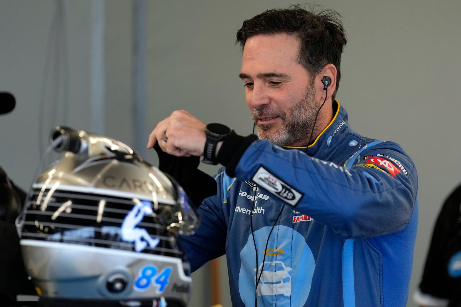 Jimmie Johnson prepares his helmet during a practice for the NASCAR Daytona 500 auto race Friday, Feb. 14, 2025, at Daytona International Speedway in Daytona Beach, Fla. (AP Photo/Chris O'Meara)