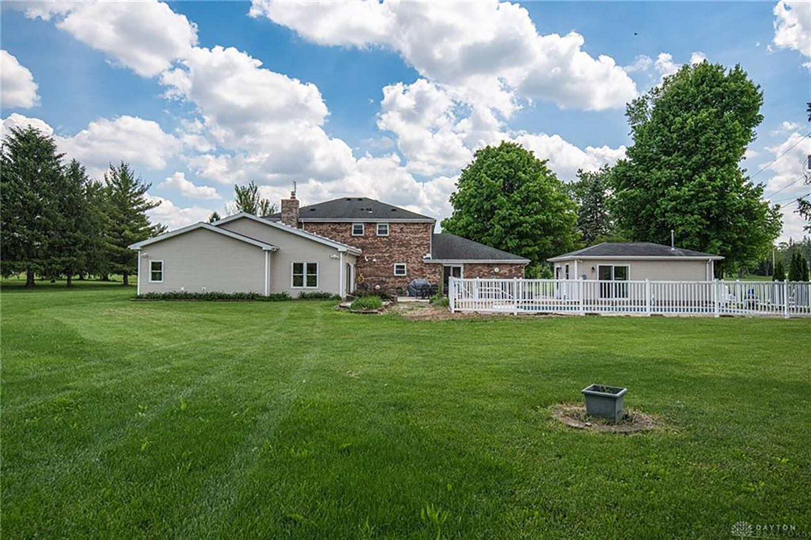 The rear of the home has a fenced in-ground pool, detached, heated workshop and vinyl-sided addition.