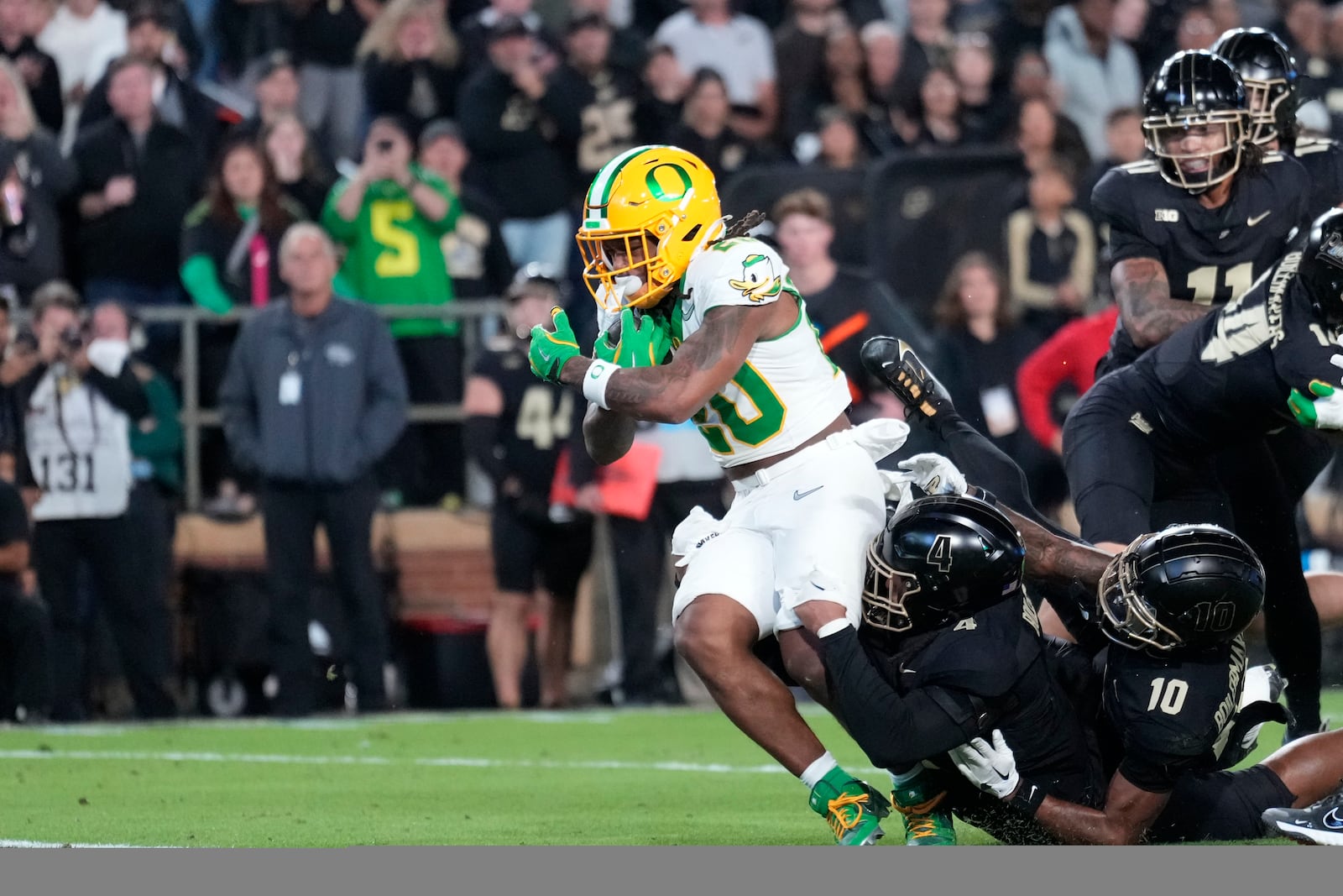 Oregon running back Jordan James (20) scores a touchdown while being tackled by Purdue linebacker Kydran Jenkins (4) in the first half of an NCAA college football game in West Lafayette, Ind., Friday, Oct. 18, 2024. (AP Photo/AJ Mast)