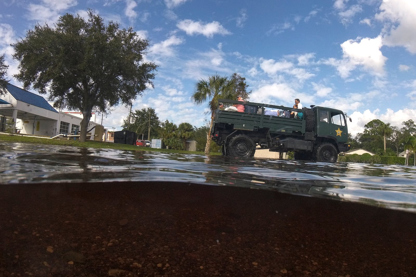 Panellas County Sheriff officials escort residents into the Tarpon Woods neighborhood as people return to their homes following Hurricane Milton, Friday, Oct. 11, 2024, in Palm Harbor, Fla. (AP Photo/Julio Cortez)