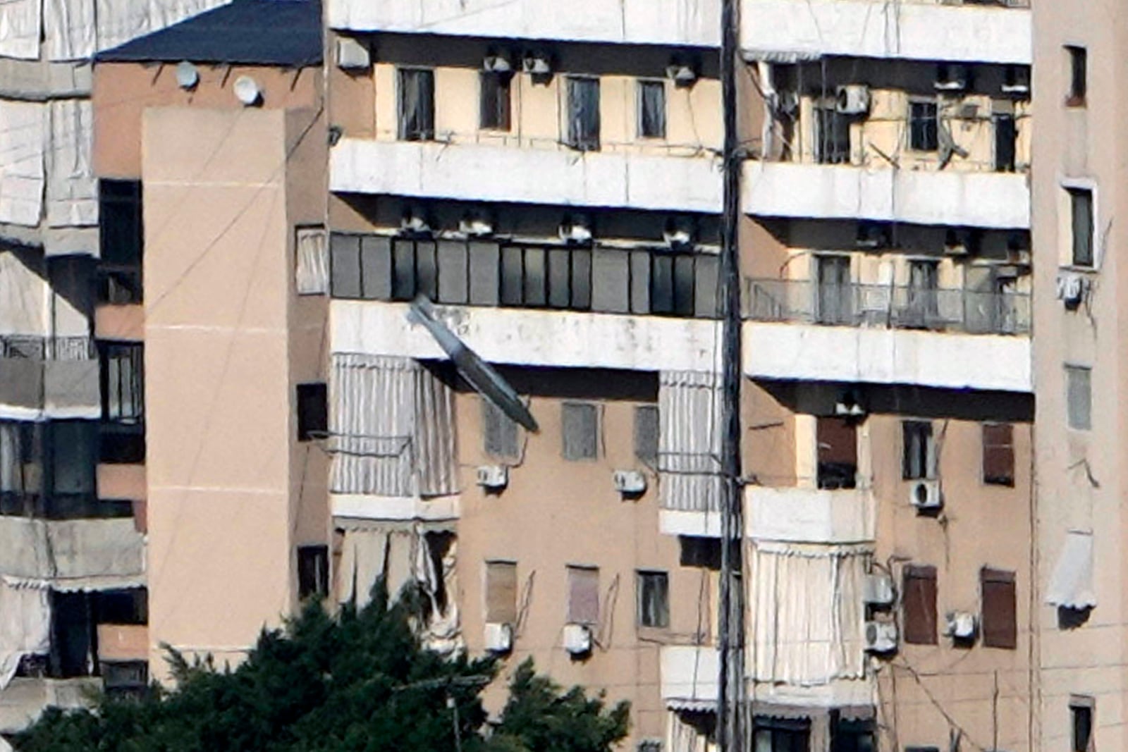 A bomb, center, dropped from an Israeli airplane falls towards a building in Dahiyeh, in the southern suburb of Beirut, Lebanon, Saturday, Nov. 16, 2024. (AP Photo/Bilal Hussein)