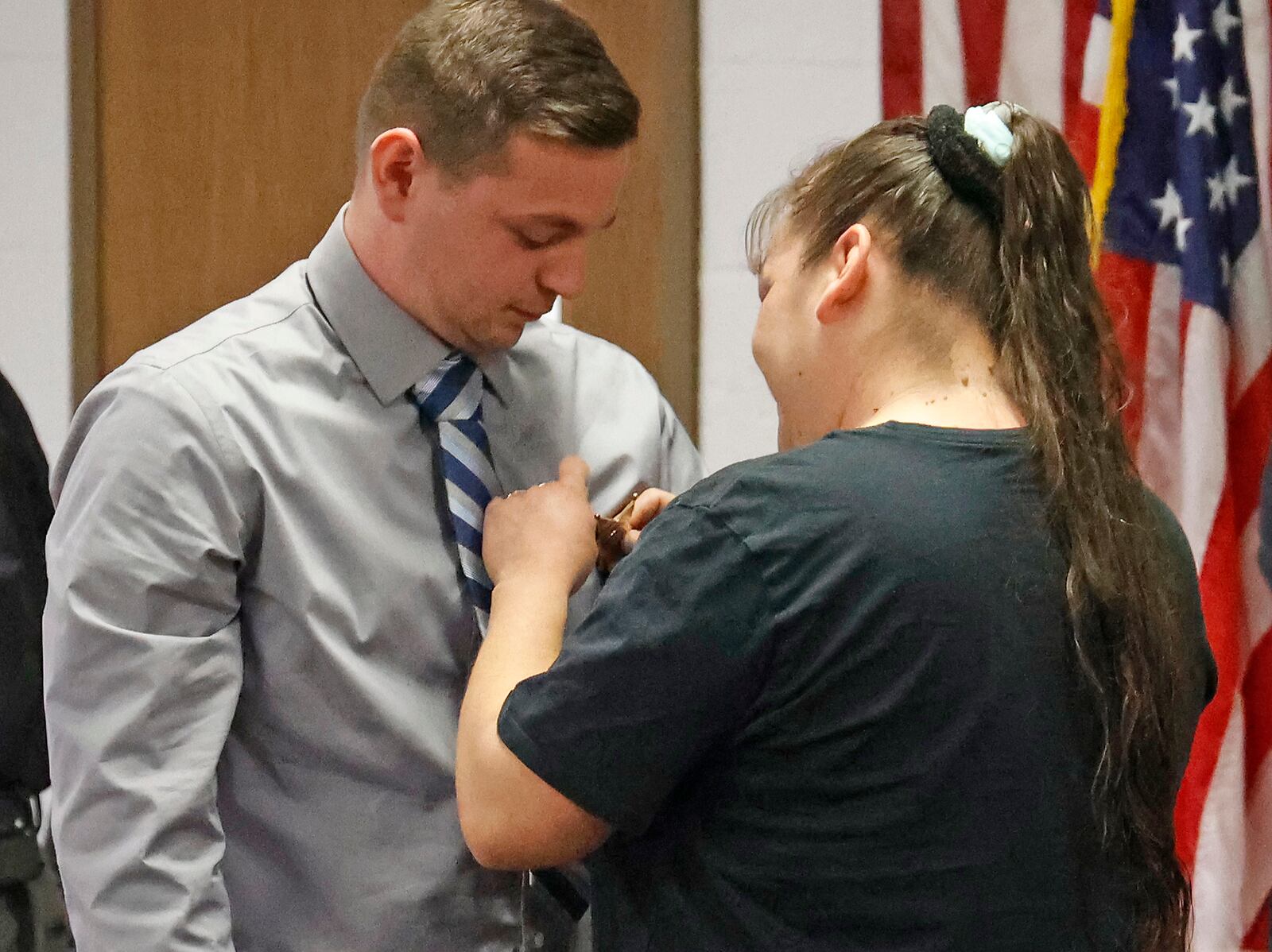 Elizabeth Gutierrez pins Zachary Speckman's badge on him as he's sworn in with five other corrections officers and five deputies Monday, Nov. 14, 2022. BILL LACKEY/STAFF