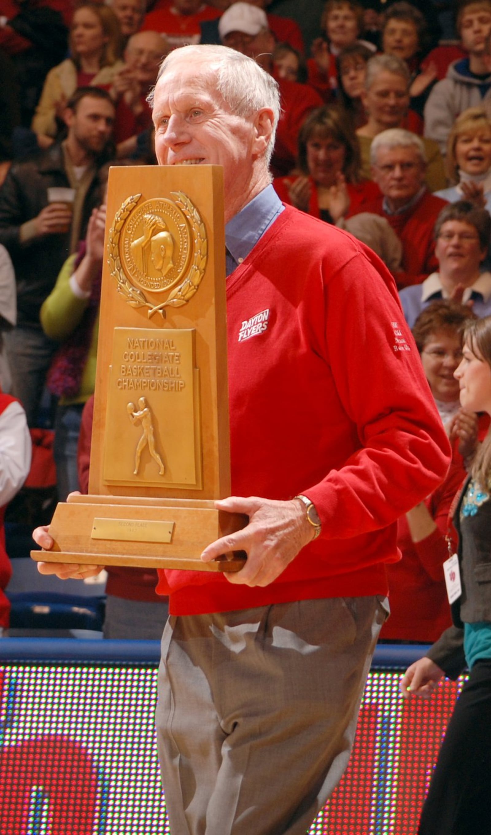 Former Dayton men’s basketball coach Don Donoher carries the 1967 NCAA Championship runner-up trophy. FILE PHOTO