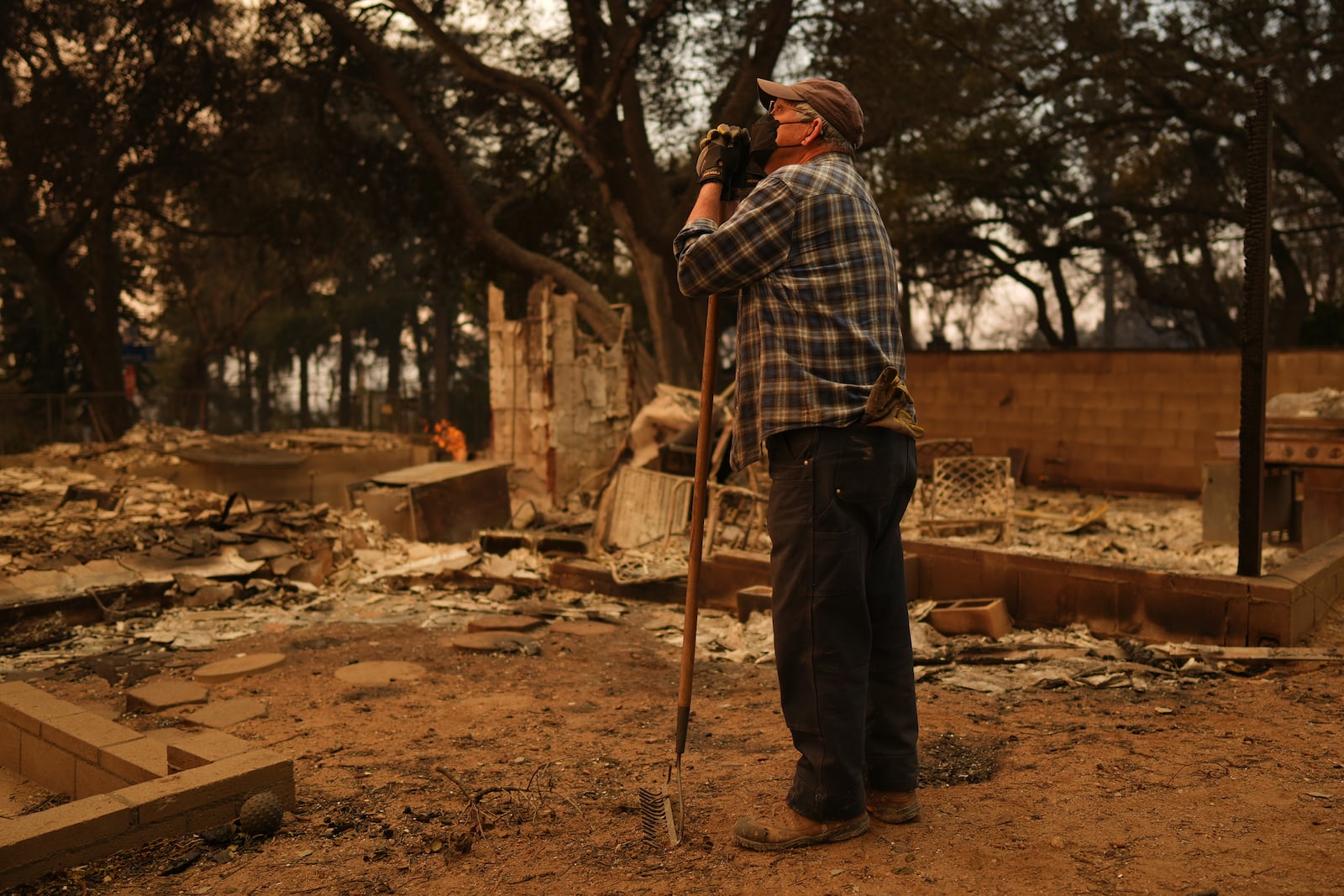 Paul Perri searches through his daughter's fire-ravaged property in the aftermath of the Eaton Fire Thursday, Jan. 9, 2025 in Altadena, Calif. (AP Photo/Eric Thayer)