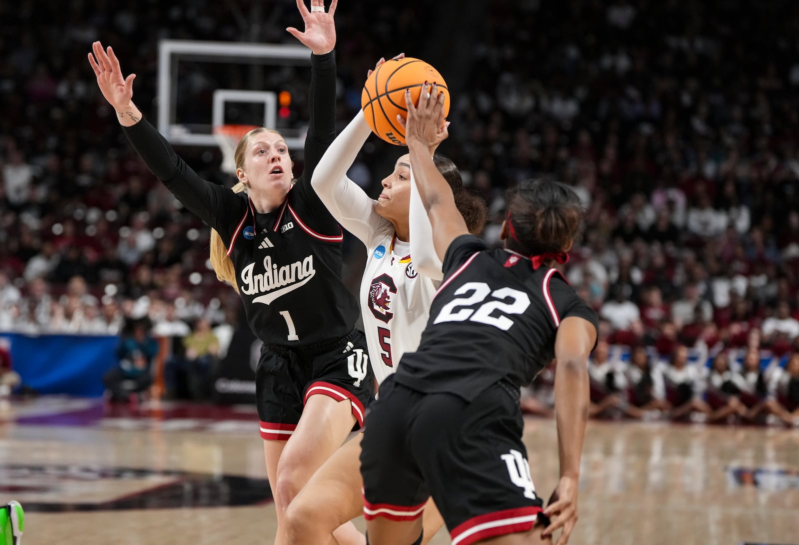 South Carolina guard Tessa Johnson (5) is squeezed by Indiana guards Lexus Bargesser (1) and Chloe Moore-McNeil (22) during the first half in the second round of the NCAA college basketball tournament, Sunday, March 23, 2025, in Columbia, S.C. (AP Photo/David Yeazell)