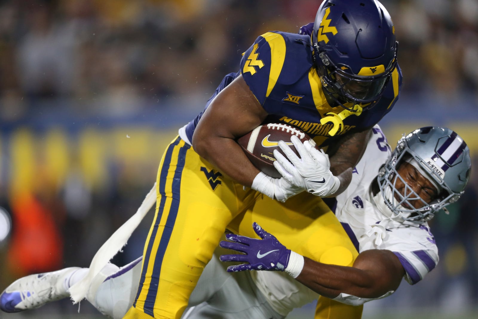 West Virginia running back CJ Donaldson Jr. (4) is tackled by Kansas State linebacker Desmond Purnell (32) during the first half of an NCAA college football game, Saturday, Oct. 19, 2024, in Morgantown, W.Va. (AP Photo/William Wotring)