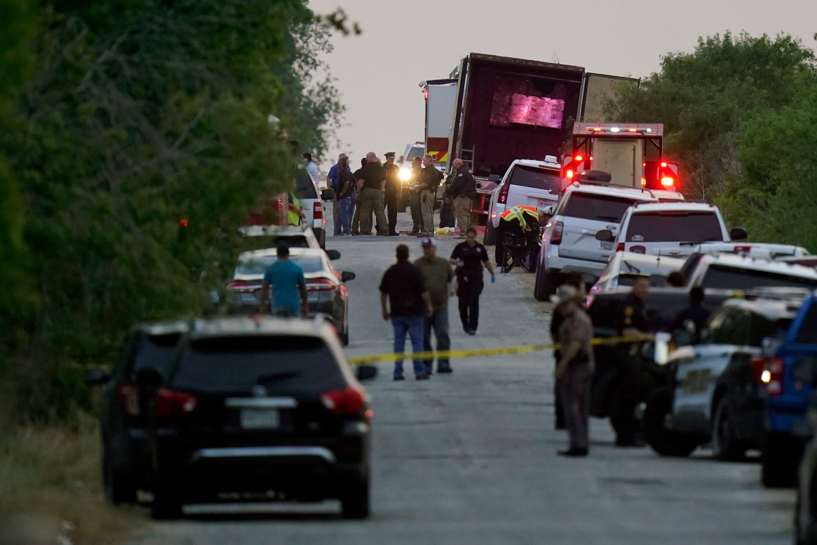 FILE - Police and other first responders work the scene where officials say dozens of people have been found dead and multiple others were taken to hospitals with heat-related illnesses after a tractor-trailer containing suspected migrants was found on June 27, 2022, in San Antonio. (AP Photo/Eric Gay, File)