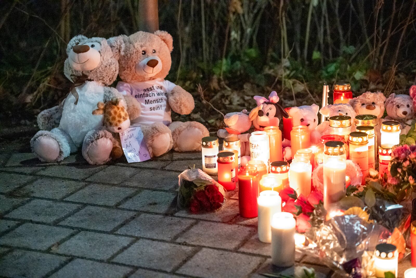 Two teddy bears and numerous candles are placed in Aschaffenburg, Germany, Thursday, Jan. 23, 2025 following the fatal attack in a park. (Daniel Vogl/dpa via AP)