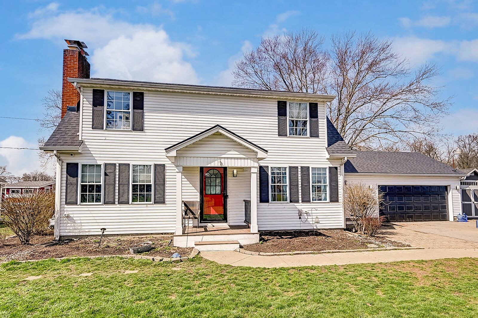 the front of the home features a covered porch with concrete floor and two car attached garage.