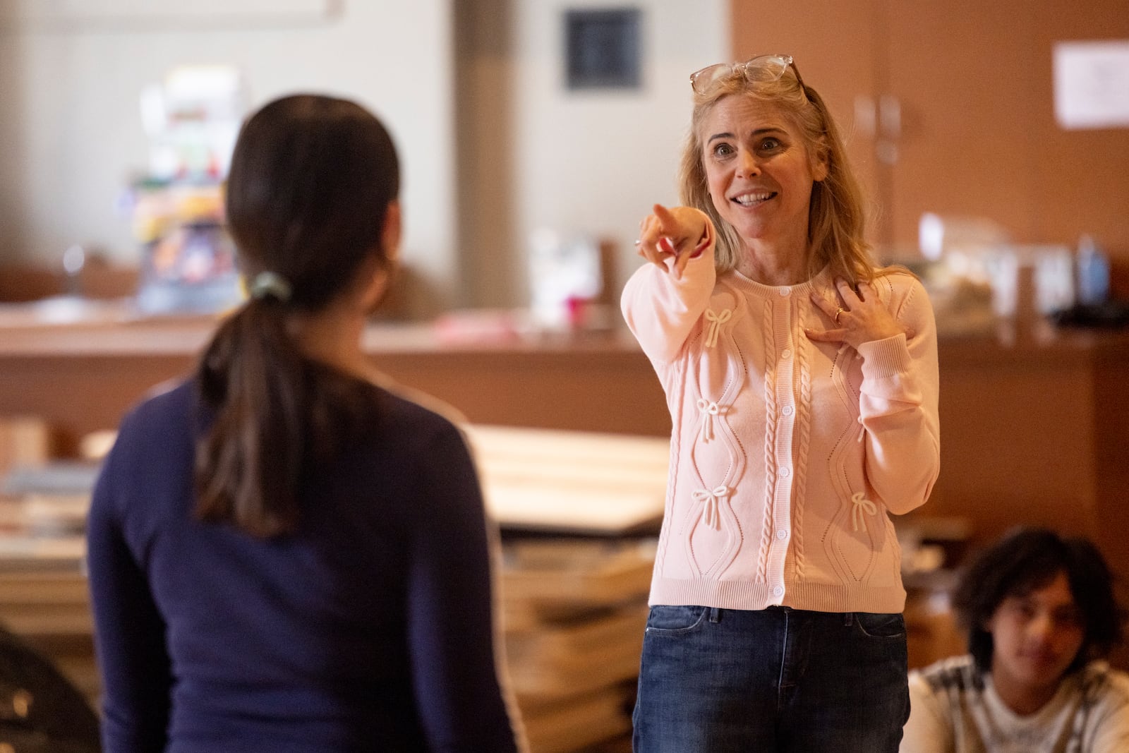 American actress and singer Kerry Butler, right, interacts with a student of the Theatre Palisades' youth theater program during a master class after their theatre was destroyed by the Palisades Fire, at the Saint Monica Preparatory's auditorium in Santa Monica, Calif., Sunday, Jan. 26, 2025. (AP Photo/Etienne Laurent)