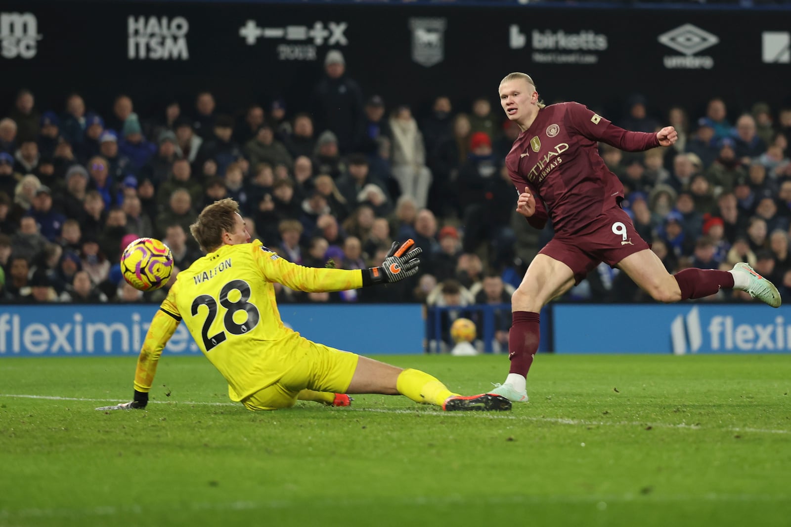 Manchester City's Erling Haaland, right, scores his side's 5th goal in front of Ipswich Town's goalkeeper Christian Walton during the English Premier League soccer match between Ipswich Town and Manchester City at Portman Road stadium in Ipswich, England, Sunday, Jan. 19, 2025. (AP Photo/Ian Walton)