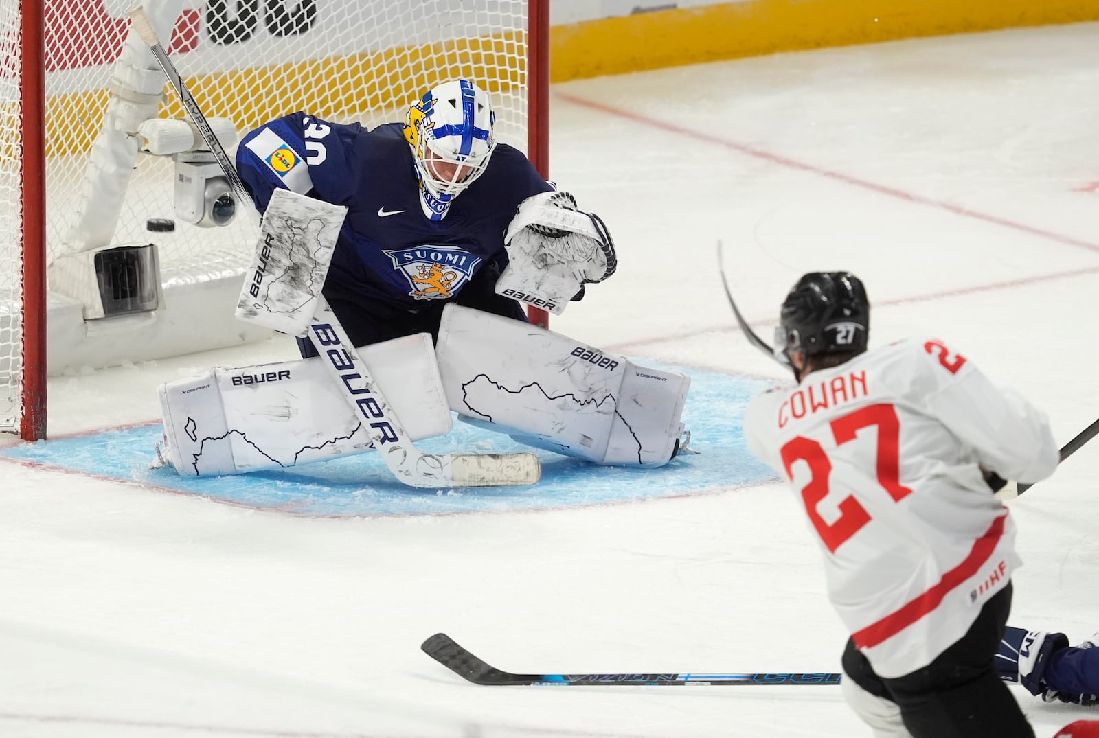 Canada forward Easton Cowan (27) shoots the puck past Finland goaltender Petteri Rimpinen (30) to score during second-period IIHF World Junior Hockey Championship tournament game action Thursday, Dec. 26, 2024, in Ottawa, Ontario. (Adrian Wyld/The Canadian Press via AP)